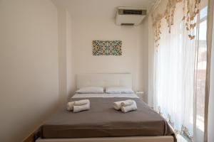 a bedroom with a bed with towels on it at Luxury Domus Apartment in SantʼAgata di Militello