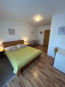 a bedroom with a bed with a green comforter at Apartment Mila in Plitvička Jezera +49 photos