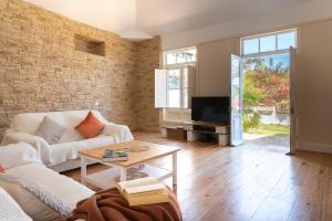 ein Wohnzimmer mit einem weißen Sofa und einem Fernseher in der Unterkunft La Casita, in the heart of Puerto De la Cruz in Puerto de la Cruz