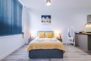 Un dormitorio con una cama grande con almohadas amarillas. en Old Bank Apartment Complex, en Bolton