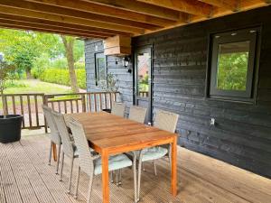 a wooden table and chairs on a deck at Chalet Zuiderzicht in Odoornerveen