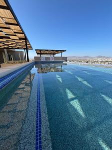 a large swimming pool with a table in the middle at Apartment with Excellent Ocean View, Terra 194 in Cabo San Lucas