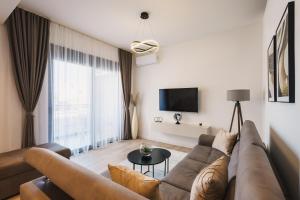 a living room with a couch and a tv at Dani Deluxe Apartments in Ulcinj