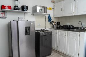 eine Küche mit einem Kühlschrank aus Edelstahl und einem Herd in der Unterkunft Apartamento Parque Central Guatapé in Guatapé + 1 Foto