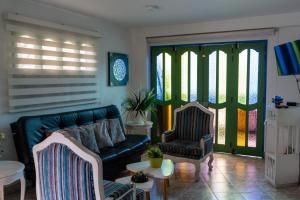 a living room with a couch and two chairs at Apartamento Parque Central Guatapé in Guatapé