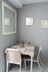 ein Esstisch mit zwei Stühlen und einer weißen Wand in der Unterkunft Apartamento Parque Central Guatapé in Guatapé