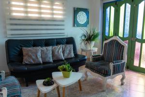 ein Wohnzimmer mit einer schwarzen Couch und einem Sessel in der Unterkunft Apartamento Parque Central Guatapé in Guatapé