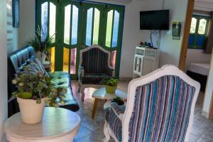 ein Wohnzimmer mit zwei Stühlen und einem Tisch in der Unterkunft Apartamento Parque Central Guatapé in Guatapé