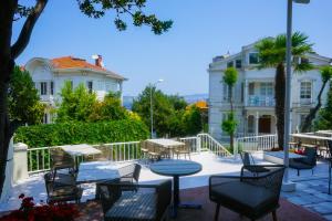 a patio with tables and chairs in front of a building at Palm Villa Büyükada in Istanbul