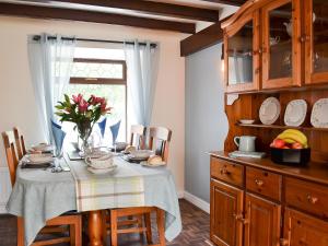 a kitchen with a table with a vase of flowers on it at Puffin Cottage in Bempton