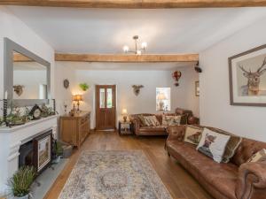 a living room with a couch and a fireplace at Harpers Cottage in Barrowford