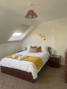 Un dormitorio con una cama grande con sábanas y almohadas blancas. en Elegant home for your relaxation, en Bletchley