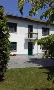 een wit huis met een groene deur en een balkon bij Affittacamere Giudici in Lentate sul Seveso