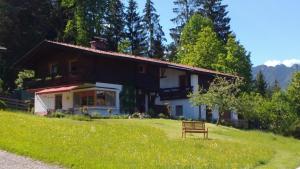 una casa en una colina con un banco en el césped en Haus Jakob, en Bischofswiesen