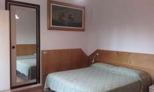 een slaapkamer met een bed en een spiegel bij Affittacamere Giudici in Lentate sul Seveso