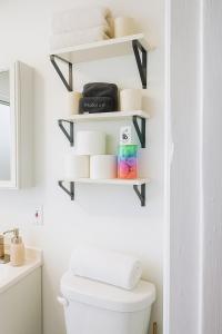 a bathroom with white shelves above a toilet at Spacious 4BR near NYC with Parking, 10min MetLife, 20min Times Sq in North Bergen