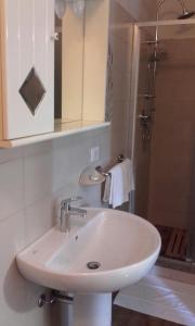 een witte wastafel in een badkamer met een douche bij Affittacamere Giudici in Lentate sul Seveso