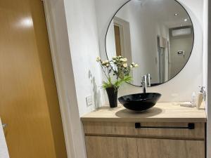 a bathroom with a black sink and a mirror at Departamento Moderno y acogedor Villa María in Villa María