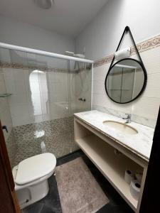 a bathroom with a toilet and a sink and a mirror at Casa da Tia Iche in Espirito Santo Do Pinhal