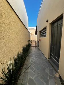 a walkway next to a building with a door at Casa da Tia Iche in Espirito Santo Do Pinhal