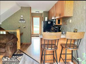 a kitchen with two bar stools in a room at Charming Lutsen Mountain Townhome with Pool Access in Lutsen