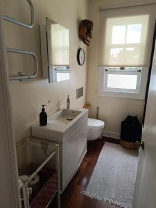 un bagno con lavandino, WC e specchio di Family House with Sea View in Angra do Heroísmo ad Angra do Heroísmo