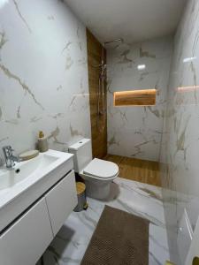 a white bathroom with a toilet and a sink at Casa Ferreira em Fátima in Fátima