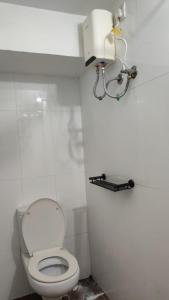 a bathroom with a toilet and a paper dispenser on the wall at Comfy home, 3 bedroom, 2 attached bathroom, large hall, kitchen, first floor, lift, covered car park in Chennai +21 photos