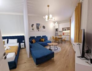 a living room with a blue couch and a table at Juar Villa - Modern Apartments in Tirana