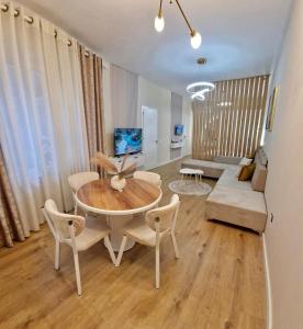 a living room with a table and a couch at Juar Villa - Modern Apartments in Tirana
