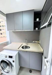 Una pequeña cocina con fregadero y lavadora. en Estudio Executivo com Wi-Fi Cozinha e Metro Centro SP, en São Paulo