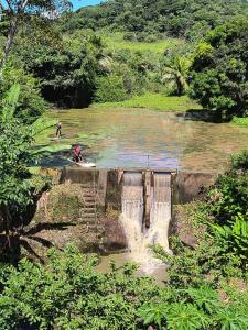 two people on surfboards in a body of water at Pousada Sítio do Engenho in Escada