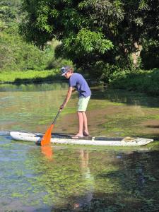a person standing on a paddle boat in the water at Pousada Sítio do Engenho in Escada