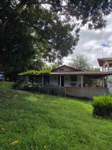 a house in a yard with a grass field at Pousada Sítio do Engenho in Escada