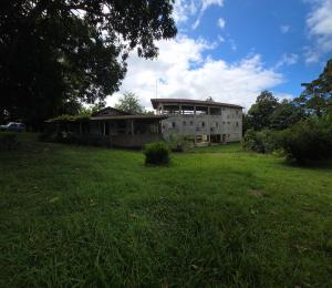 an old building in a field with a grassy yard at Pousada Sítio do Engenho in Escada