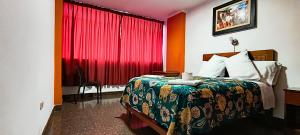 a hotel room with a bed and a red curtain at Plaza Hotel Huánuco in Huánuco
