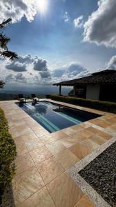 a swimming pool with two chairs next to a house at Finca Valparaíso in Sevilla