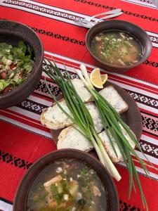 a table with three bowls of soup and some sandwiches at Khata under the Blue Flower in Medvin