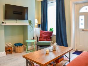 un soggiorno con un tavolo e un divano di Welsh Yard Cottage a Penrith