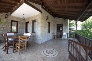 a patio with a table and chairs on a porch at Villa Olive Garden in Datca