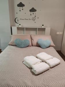 a bed with two hearts and two towels on it at Dreaming Ribera del Genil - free parking in Granada