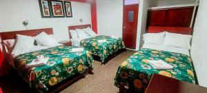 a hotel room with two beds with green blankets at Plaza Hotel Huánuco in Huánuco