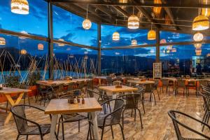 a restaurant with tables and chairs and a large window at Neusa Hills Eco Hotel Boutique in Tausa Viejo