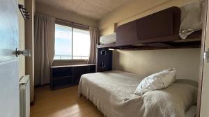 a small bedroom with a bed and a window at Balcones Al Mar in Villa Gesell