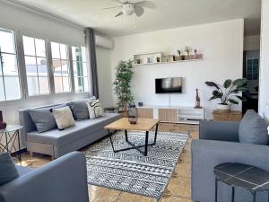 a living room with blue couches and a tv at Chalets con piscinas privadas junto al mar in Cala en Bosc