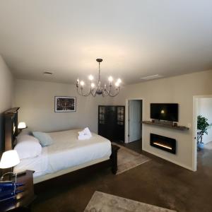 a bedroom with a large bed and a fireplace at Fredericksburg Stay W Patio, Fire Pit & Hot Tub in Fredericksburg