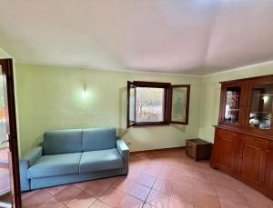 a living room with a blue couch and a window at Casa Vacanze Sole in Monte Petrosu +1 photo