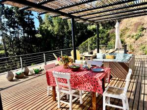 a patio with a table and chairs on a deck at Espectacular Loft en Zapallar in Zapallar