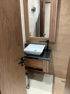 a bathroom with a white sink and a mirror at bel appartement City à centre Mahdia in Kenitra