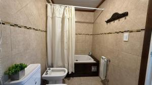 a bathroom with a toilet and a sink and a tub at Balcones Al Mar in Villa Gesell +31 photos